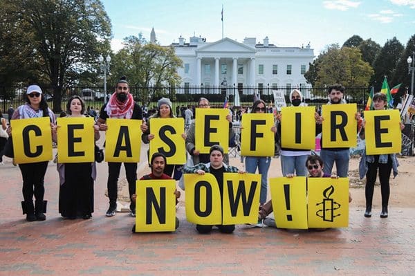 Activists hold up Ceasefire Now posters in front of White House