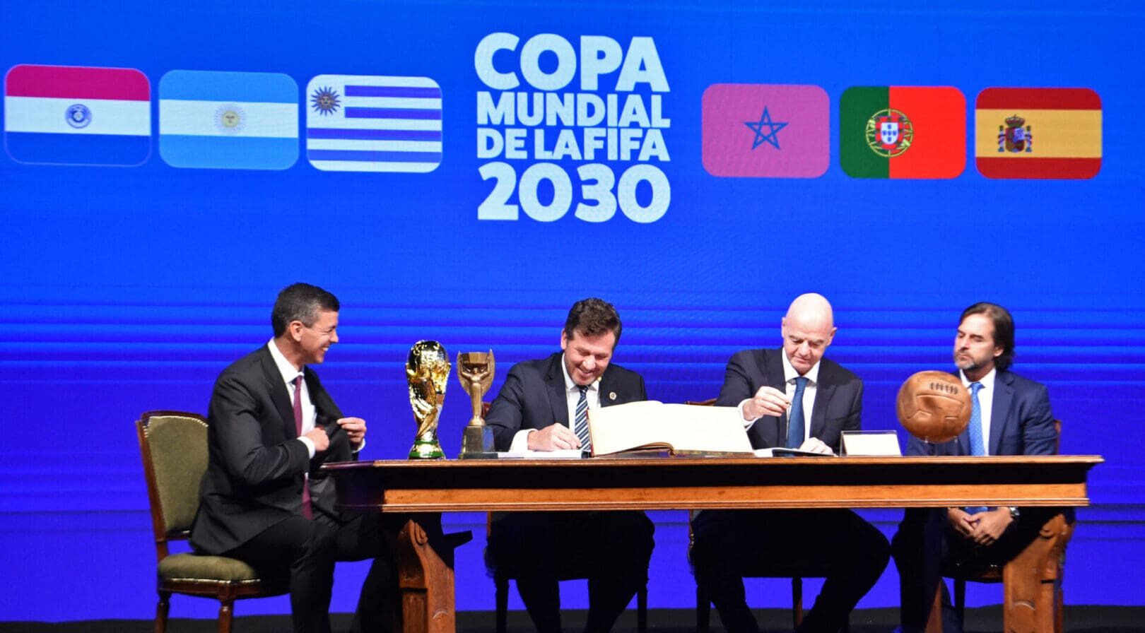 Conmebol's President Alejandro Dominguez (L-2) and FIFA President Gianni Infantino (R-2), accompanied by Paraguay's President Santiago PeÃ±a (L) and Uruguay's President Luis Lacalle(R), sign a book of minutes of the 2030 World Cup during Conmebol's 78th Ordinary Congress in Luque, Paraguay on April 11, 2024. (Photo by NORBERTO DUARTE / AFP) (Photo by NORBERTO DUARTE/AFP via Getty Images)