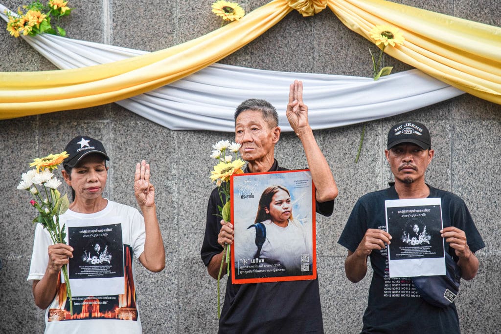 BANGKOK, THAILAND - 2024/05/14: Pro-democracy activists make three finger salute and hold portraits of Netiporn Sanesangkhom during mourning ceremony outside The Southern Bangkok Criminal Court. Thai political activist Netiporn Sanesangkhom also know as 