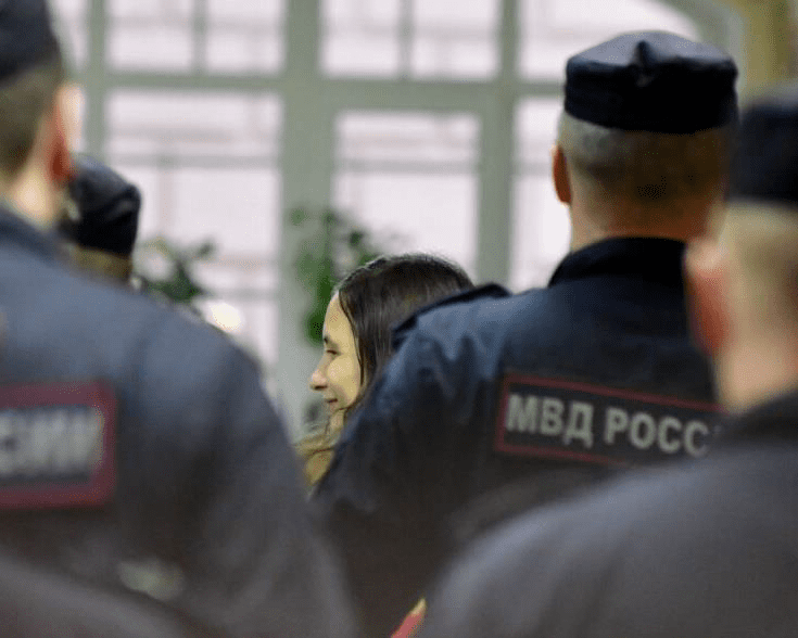 Russian artist Alexandra Skochilenko, 33, smiles as she is escorted by police officers after being sentenced to seven years in prison for spreading disinformation about the army after she swapped supermarket price tags with slogans criticising Russia's offensive in Ukraine, at a court in Saint Petersburg on November 16, 2023. Photo by OLGA MALTSEVA/AFP via Getty Images