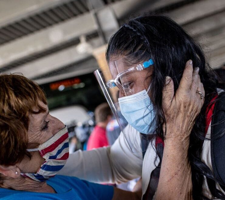 BROWNSVILLE, TEXAS - FEBRUARY 26: A Honduran asylum seeker has an emotional reunion with immigration worker Kathy Harrington from the non-profit Team Brownsville upon her arrival to the United States on February 26, 2021 in Brownsville, Texas. Her group was one of the first to cross into south Texas as part of the Biden administration's unwinding of the Trump-era Migrant Protection Protocols, (MPP), also known as the 'Remain in Mexico' immigration policy. Many of the asylum seekers had been waiting in the squalid camp alongside the Rio Grande in Matamoros for more than a year and became close to camp logistics workers, many of them American. The immigrants are now free to travel to destinations within the United States pending asylum court hearings. (Photo by John Moore/Getty Images)