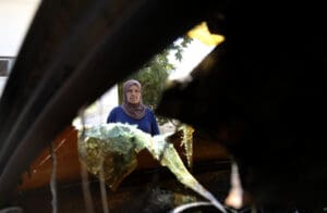 Palestinians look at the vehicles which were burnt down after an Israeli raid under the name of 